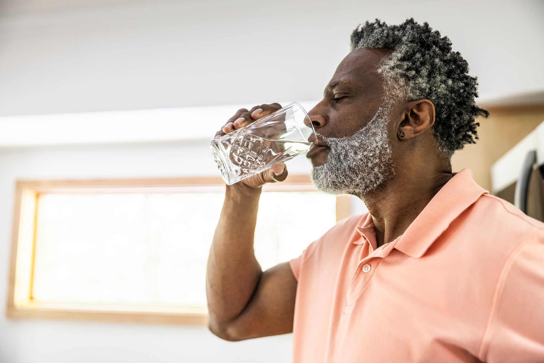 Senior man drinking water at home