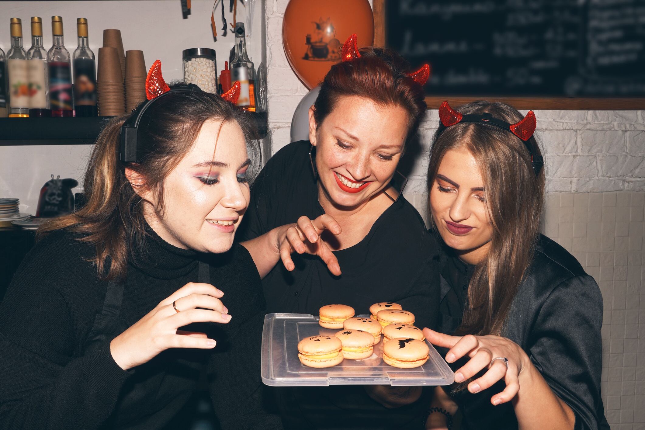 Halloween party at coffee shop, cafe. Funny grimacing women. Halloween bakery. Coffee Shop, Bar, Counter, Cafe Concept. Young entrepreneur conceptual. Irene Puzankova GettyImages