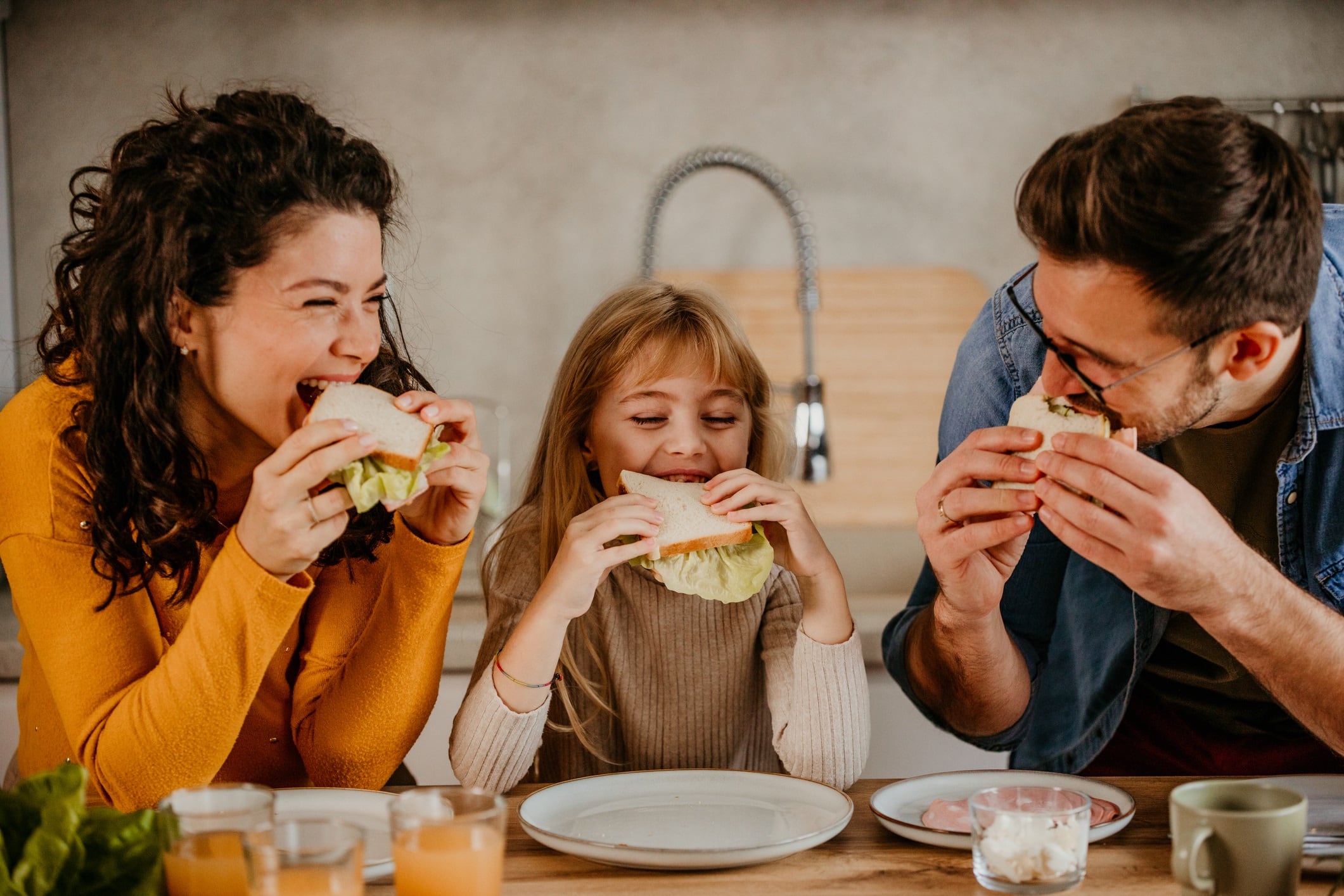 Family eating sandwiches together.