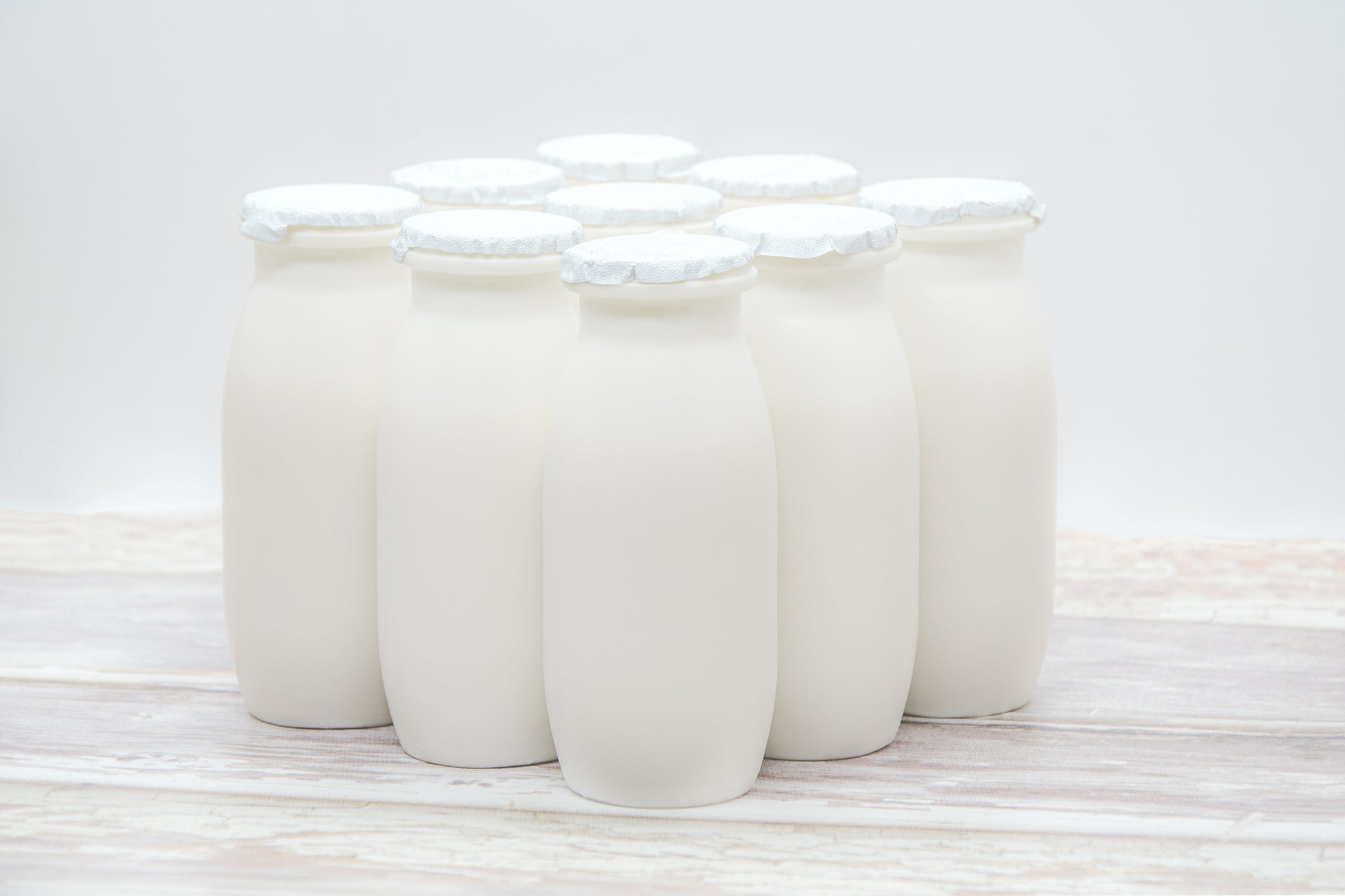Natural liquid yogurt with probiotics in small plastic bottles on wooden table. Healthy, balanced diet food, healthy breakfast, dairy products. Selective soft focus, blurred background