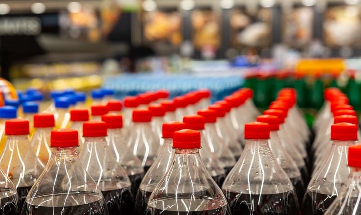 Rows of soda bottles on supermarket shelf for beverage shopping concepts