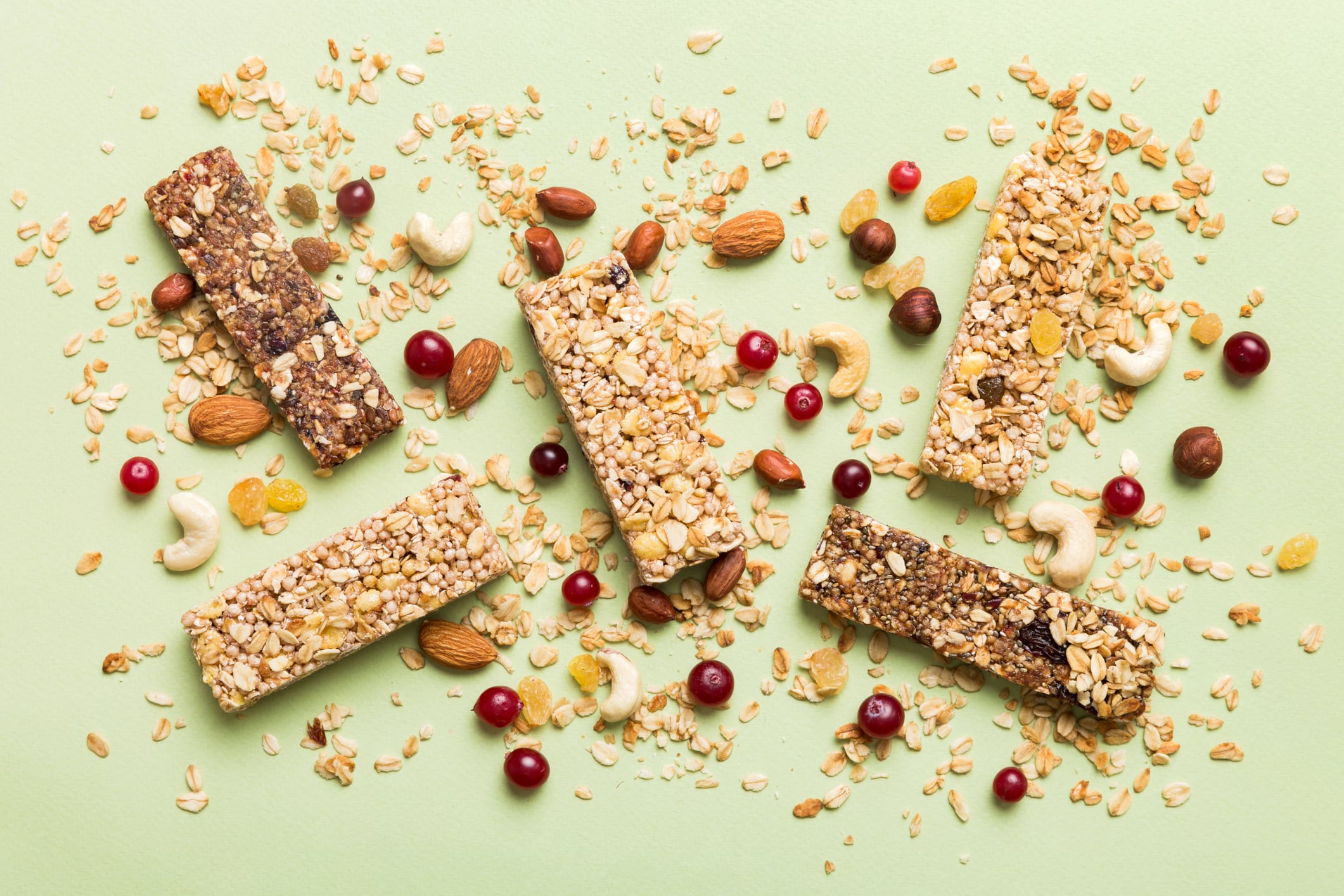 A new trend is hitting the aisles: minimally processed snacks. Various granola bars on table background. Cereal granola bars. Superfood breakfast bars with oats, nuts and berries, close up. Superfood concept.