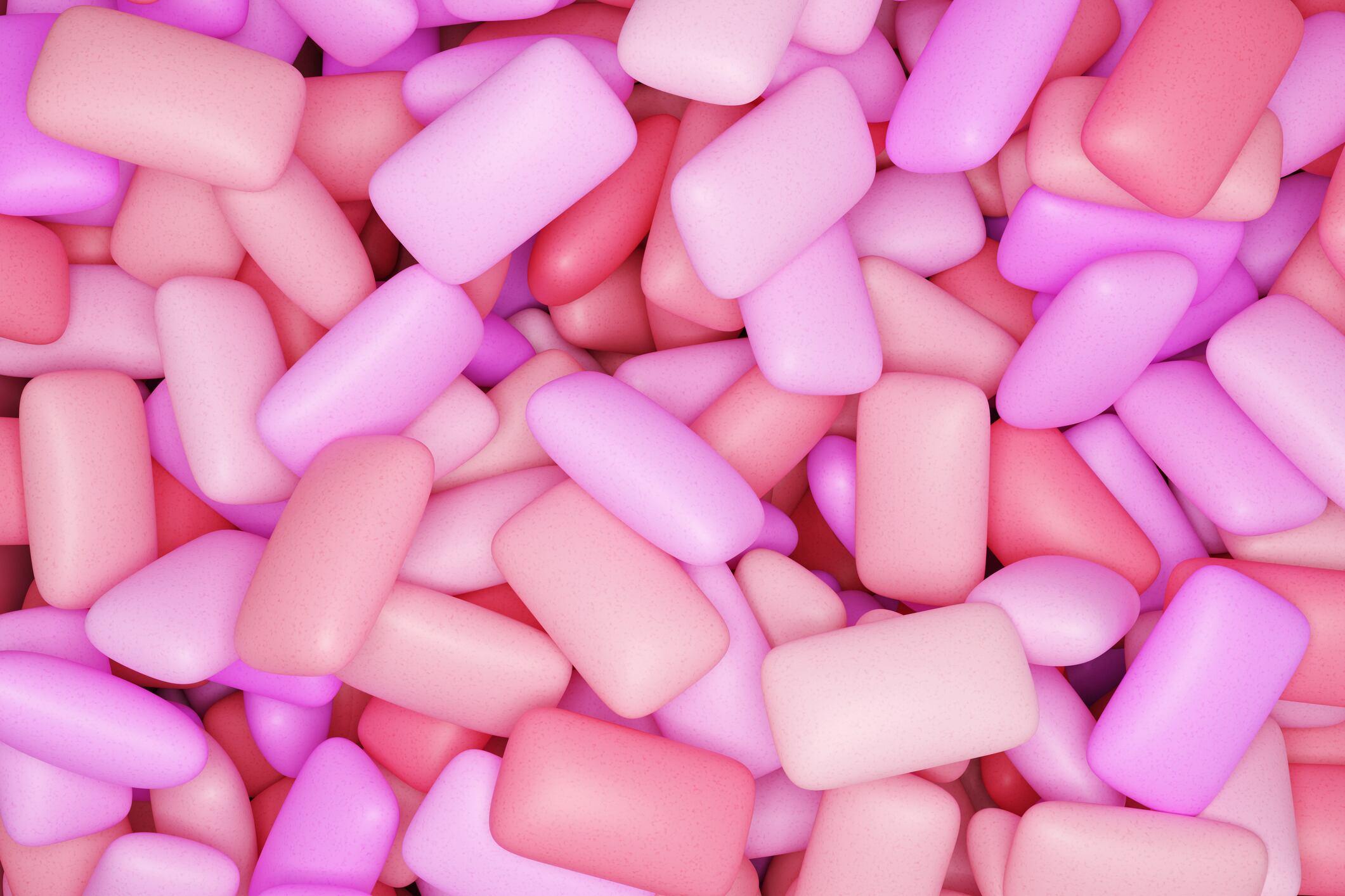 Pink rectangular chewing gum in a pile of hundreds.