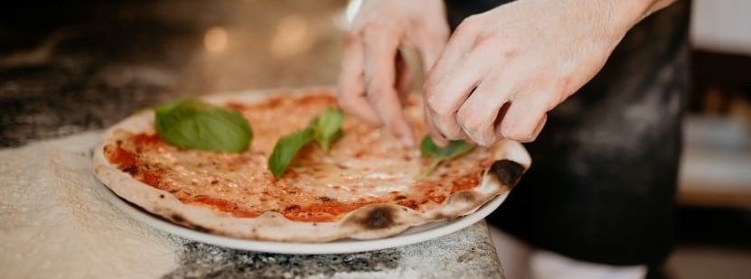 Adding basil to margherita pizza