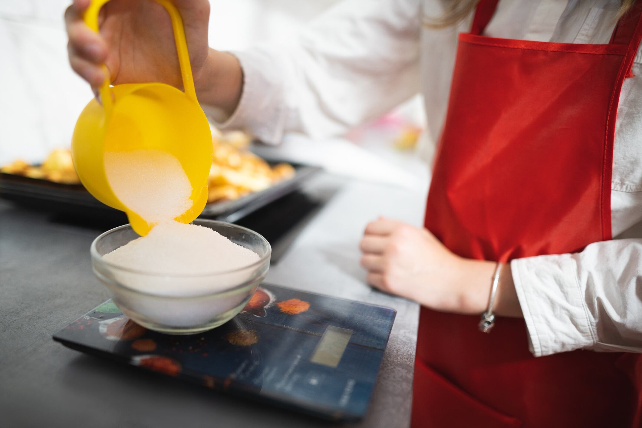 Baker measuring sugar on a scale