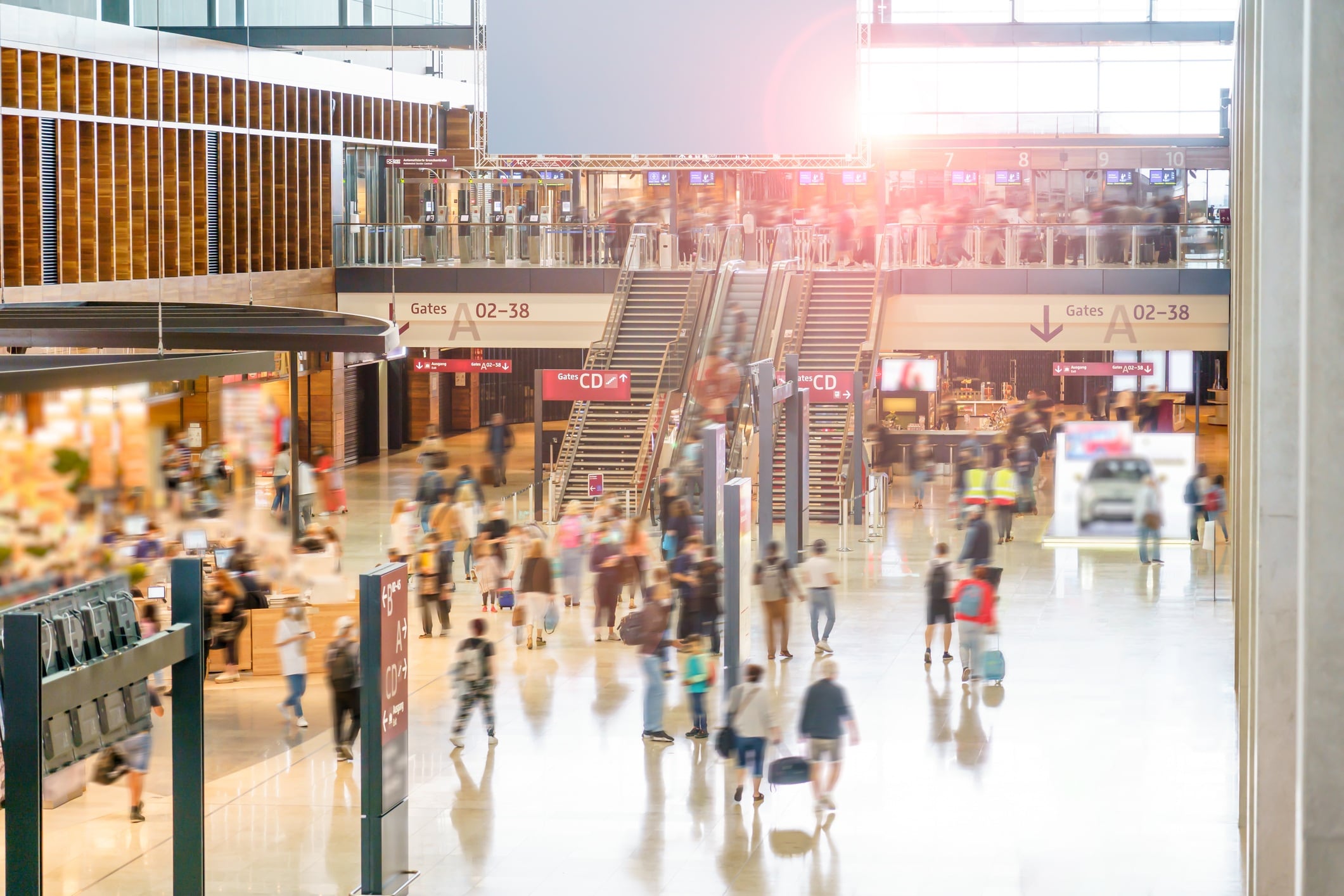 Main airport hall with duty free shops, restaurants and VIP lounges. There is a large group of travelers going to their departure gates to catch flights for business and vacation.