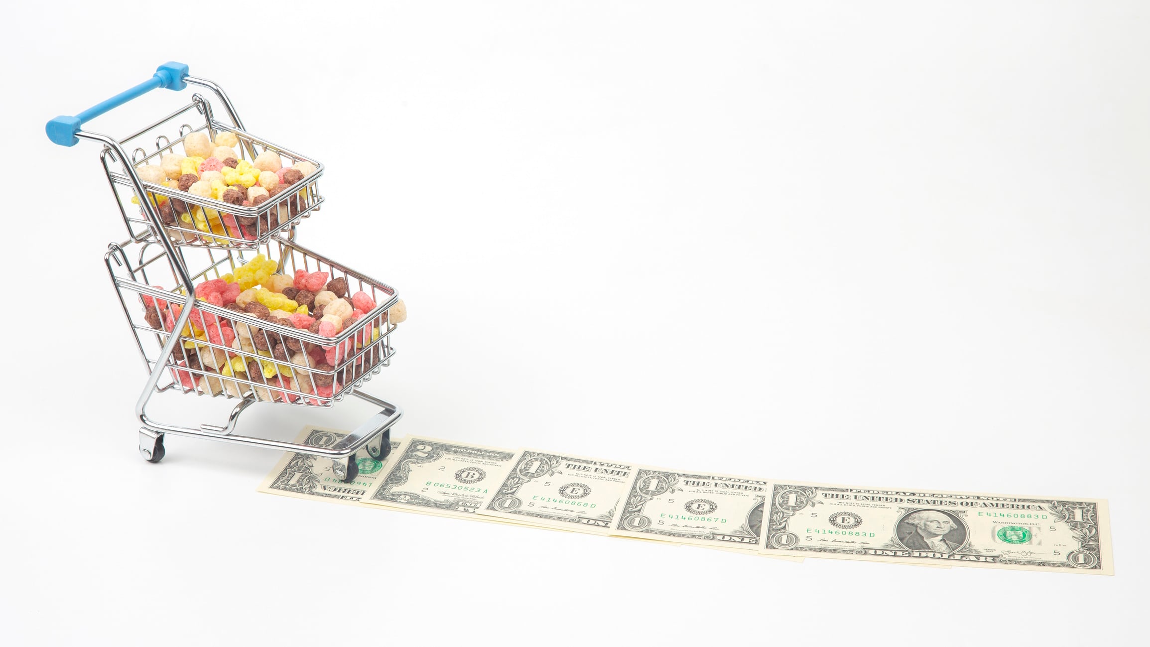 Colored light snacks in a market basket and dollars on a white background