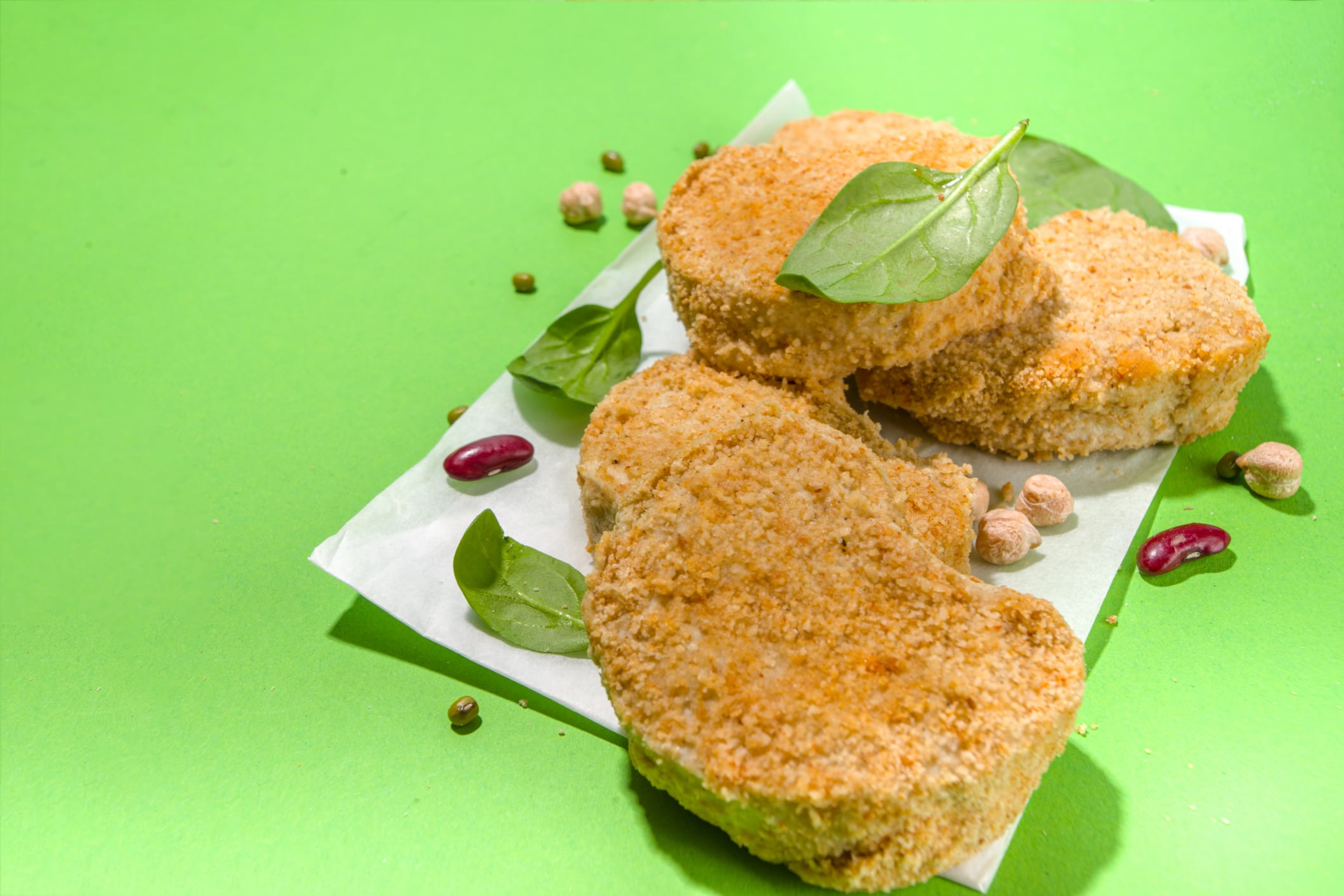 Lab-grown or plant based white meat nuggets over green background