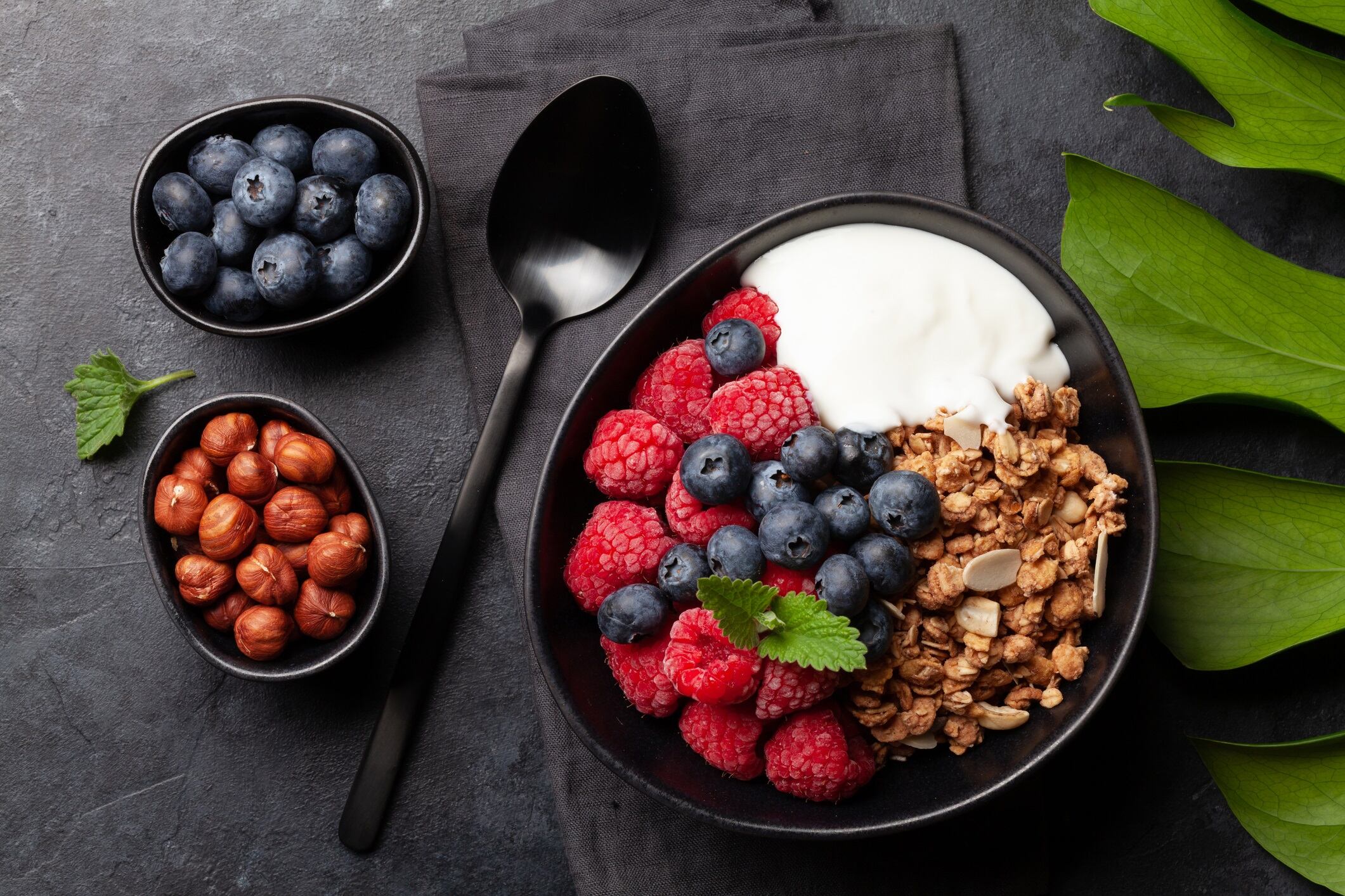 Healthy breakfast with homemade granola with yogurt and fresh berries on stone background. Top view flat lay