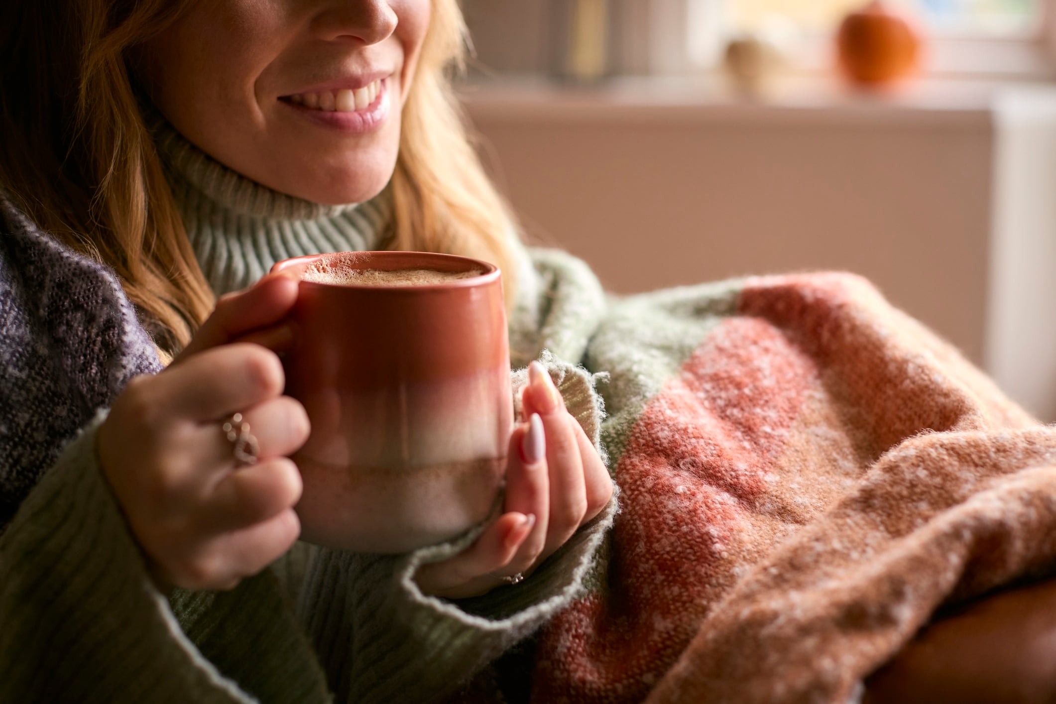Close Up Of Woman At Home Wearing Winter Jumper With Warming Hot Drink Of Coffee In Cup Or Mug