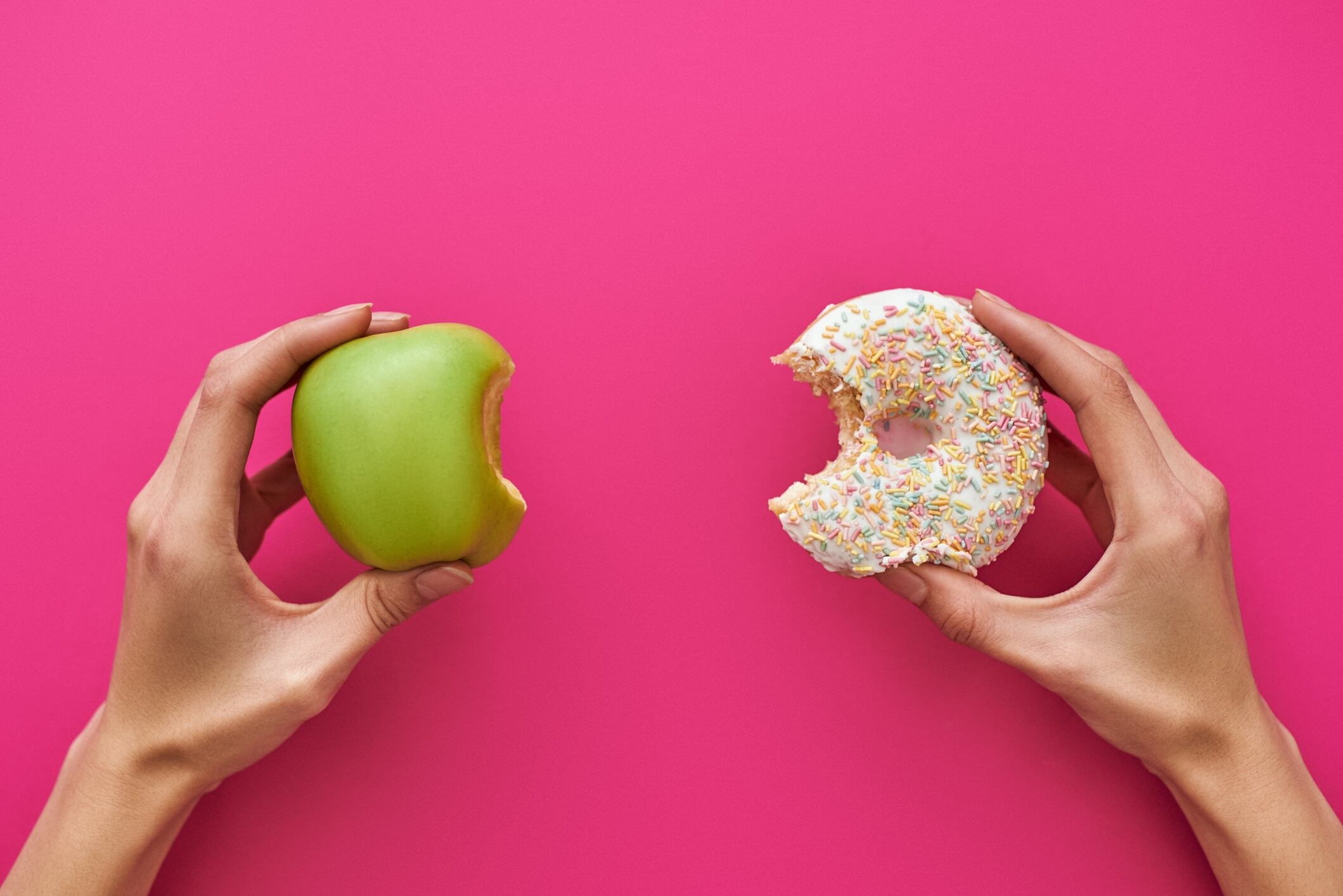 Dieting or good health concept. Choice between doughnut and apple.