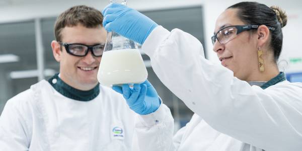 Two people in lab analysing milk