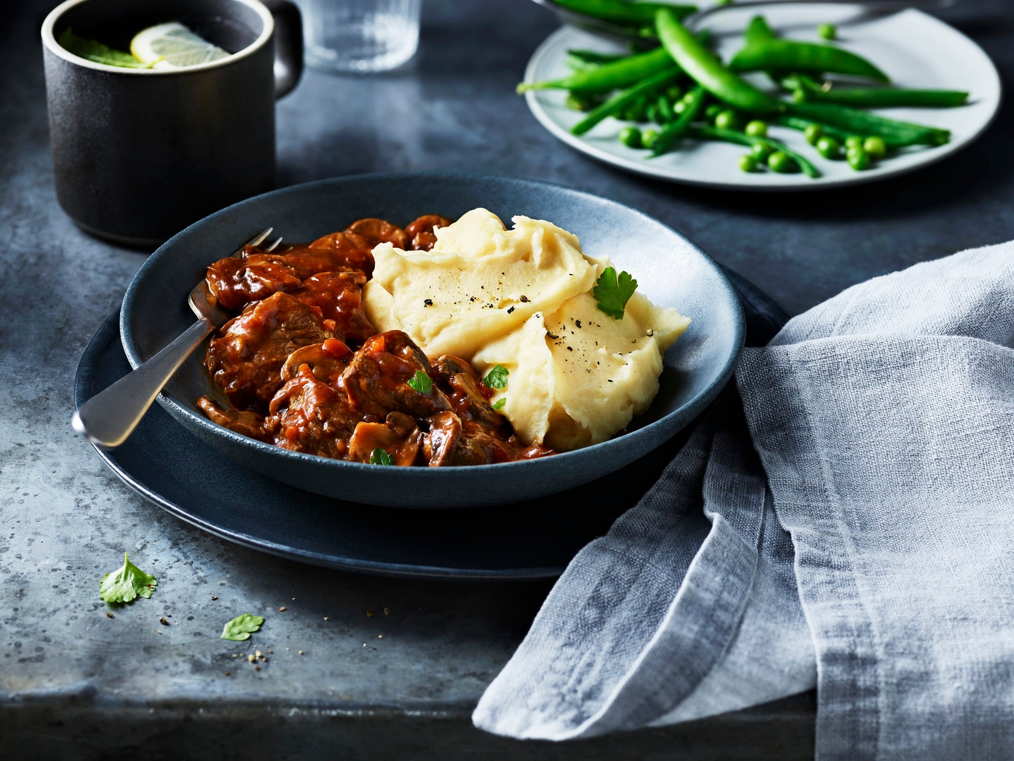 A hearty plate of beef stew with smooth mashed potatoes ready to be enjoyed