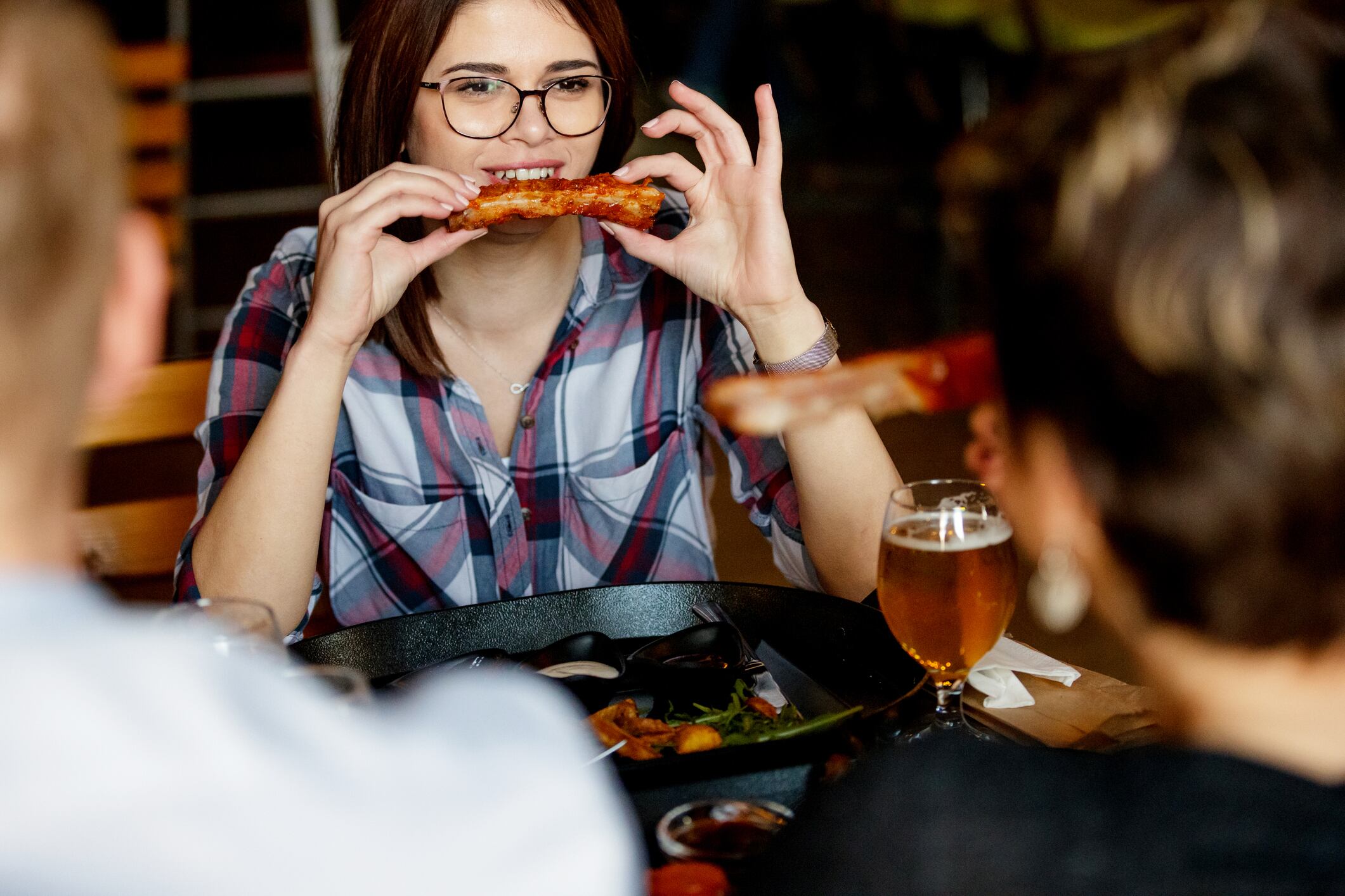 Young woman eating ribs.
