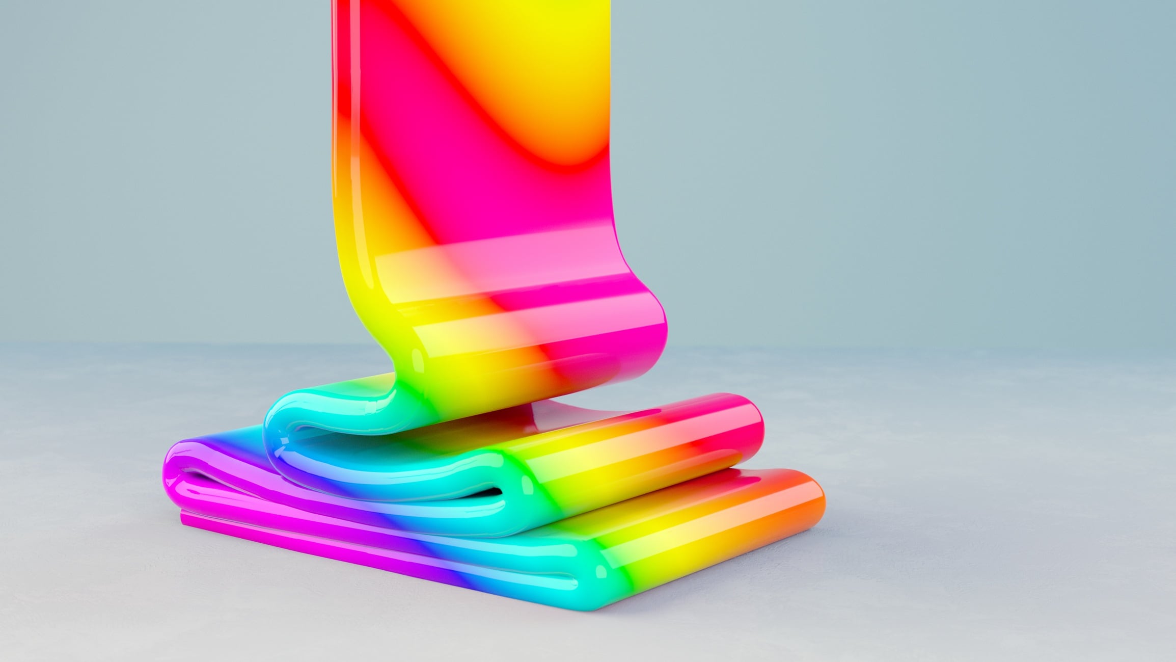 Rainbow coloured paste poured on a grey surface.