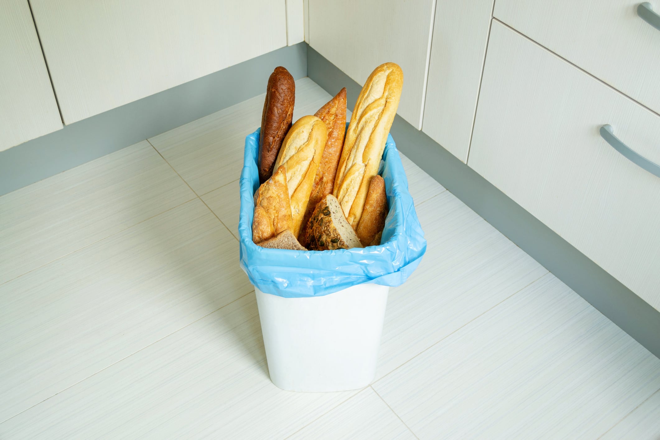 loaves, baguettes in the organic waste bin in the kitchen, copy space
