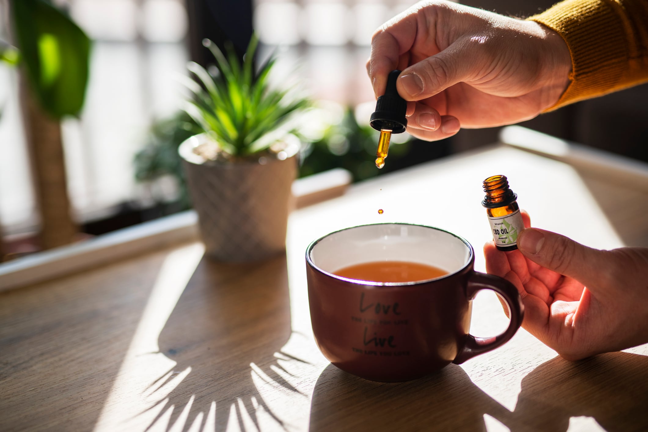 Unrecognizable man using CBD oil in his tea.