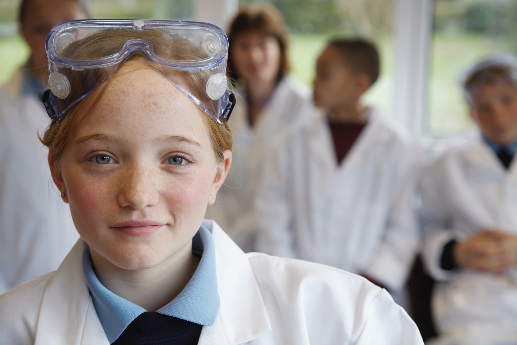 Schoolgirl (11-13) in science class, smiling, portrait (focus on girl)
