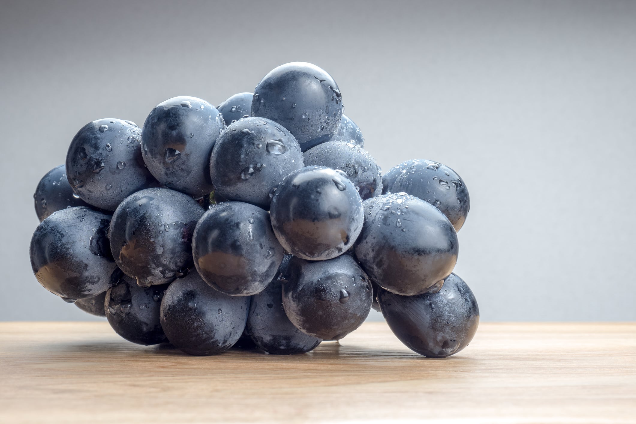A bunch of Kyoho grapes sitting on a table.