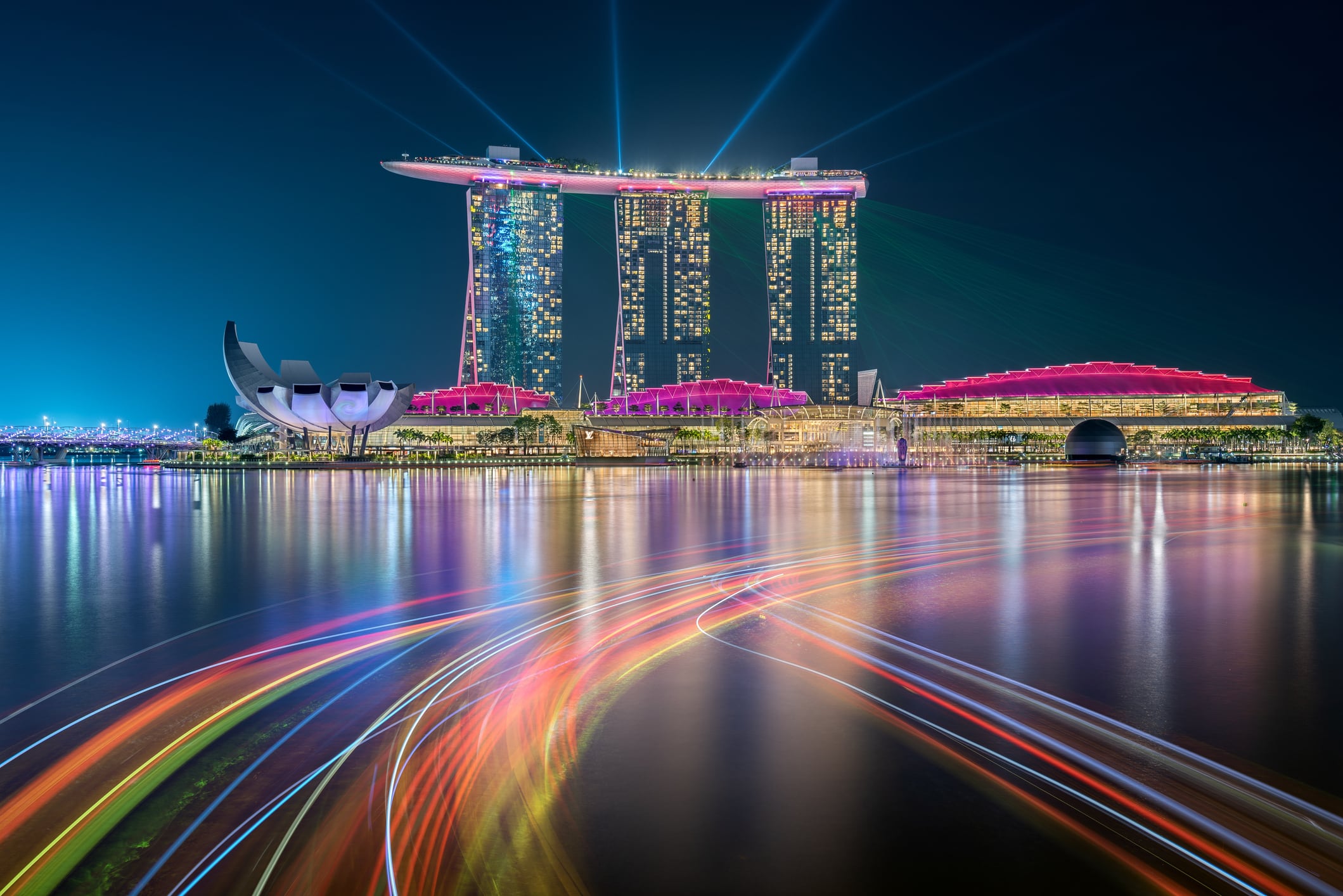 Singapore - October 24, 2019: Singapore skyline taken at night with the famous hotel Marina Bay Sands, the reflections of the buildings and the light trails of the boats painted in the bay water