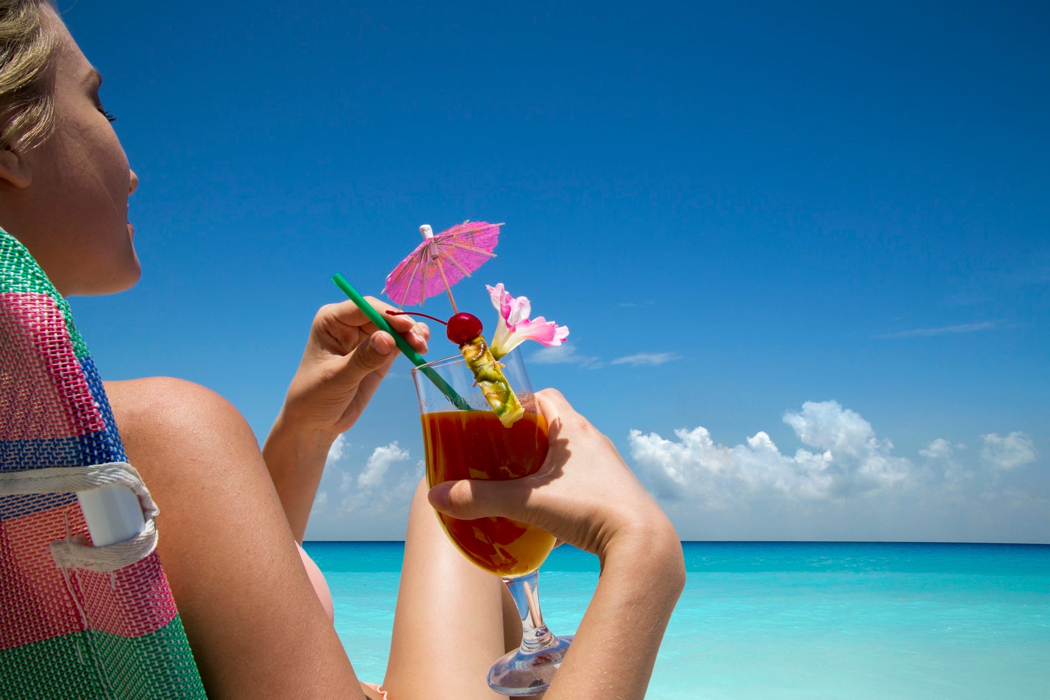 Woman with tropical drink on beach