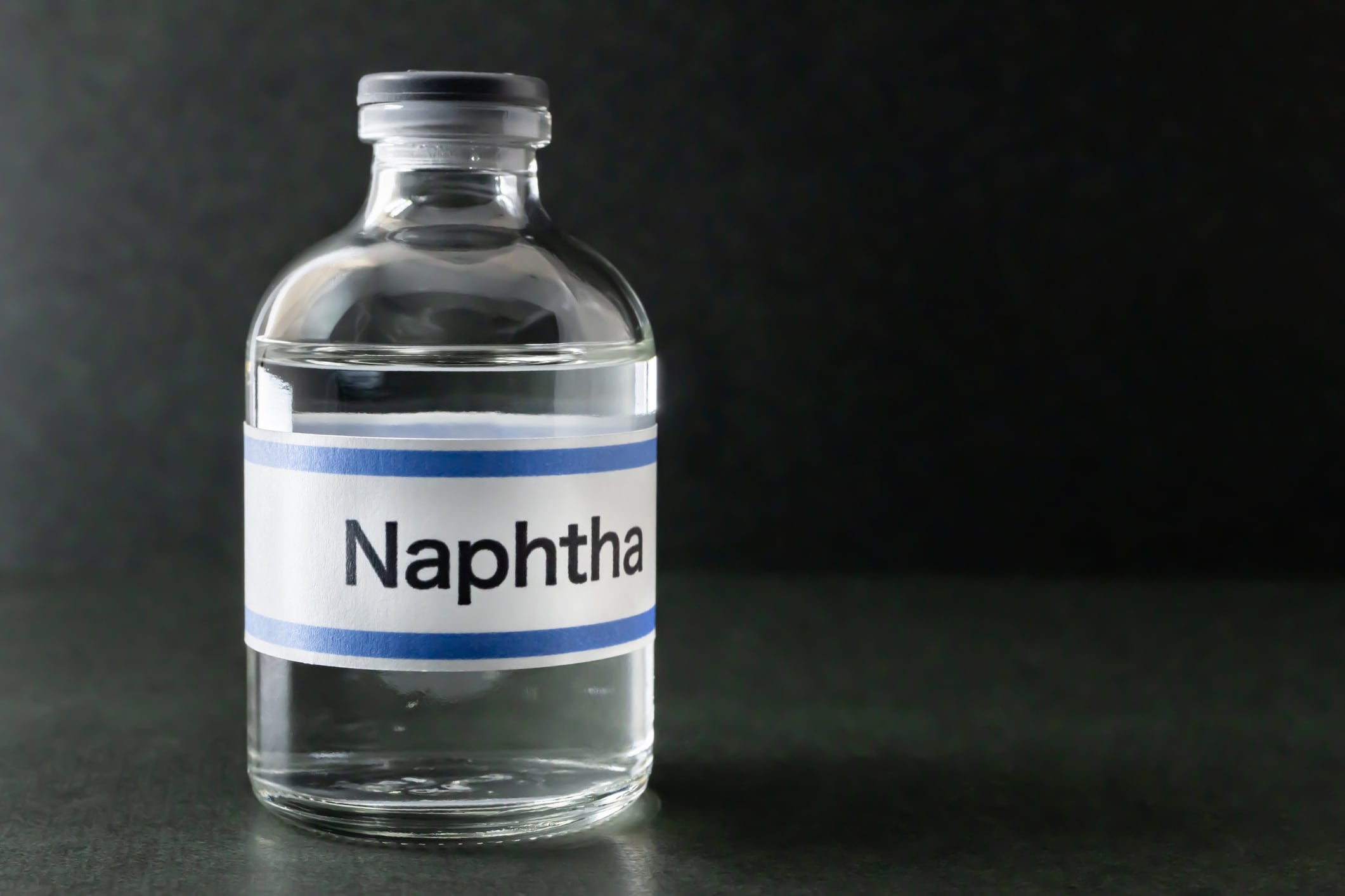 naphtha, glass bottle, liquid, black background shironagasukujira GettyImages