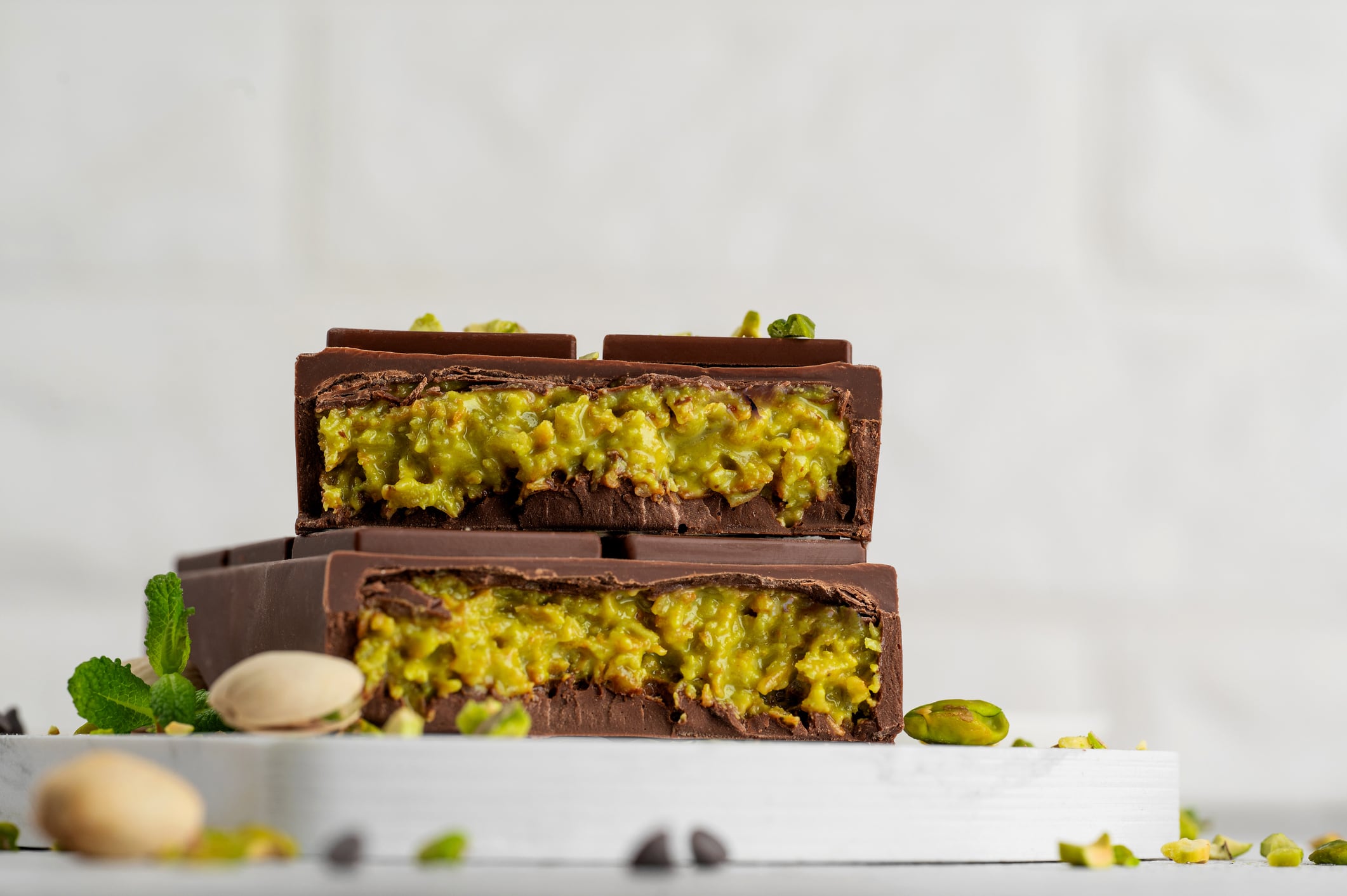 Dubai chocolate with kadayif dough and pistachio paste. Trend dessert on a board on a concrete background. Copy space