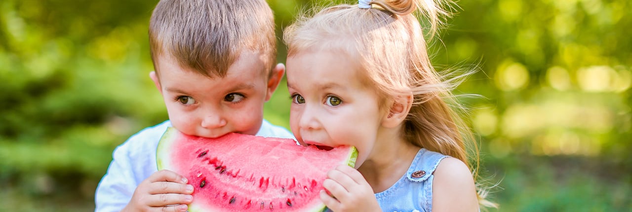 Two children eating watermelon