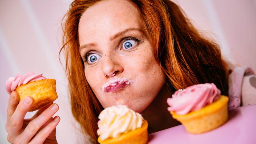 Young Woman Eating Cupcakes With A Lot Of Enthusiasm
