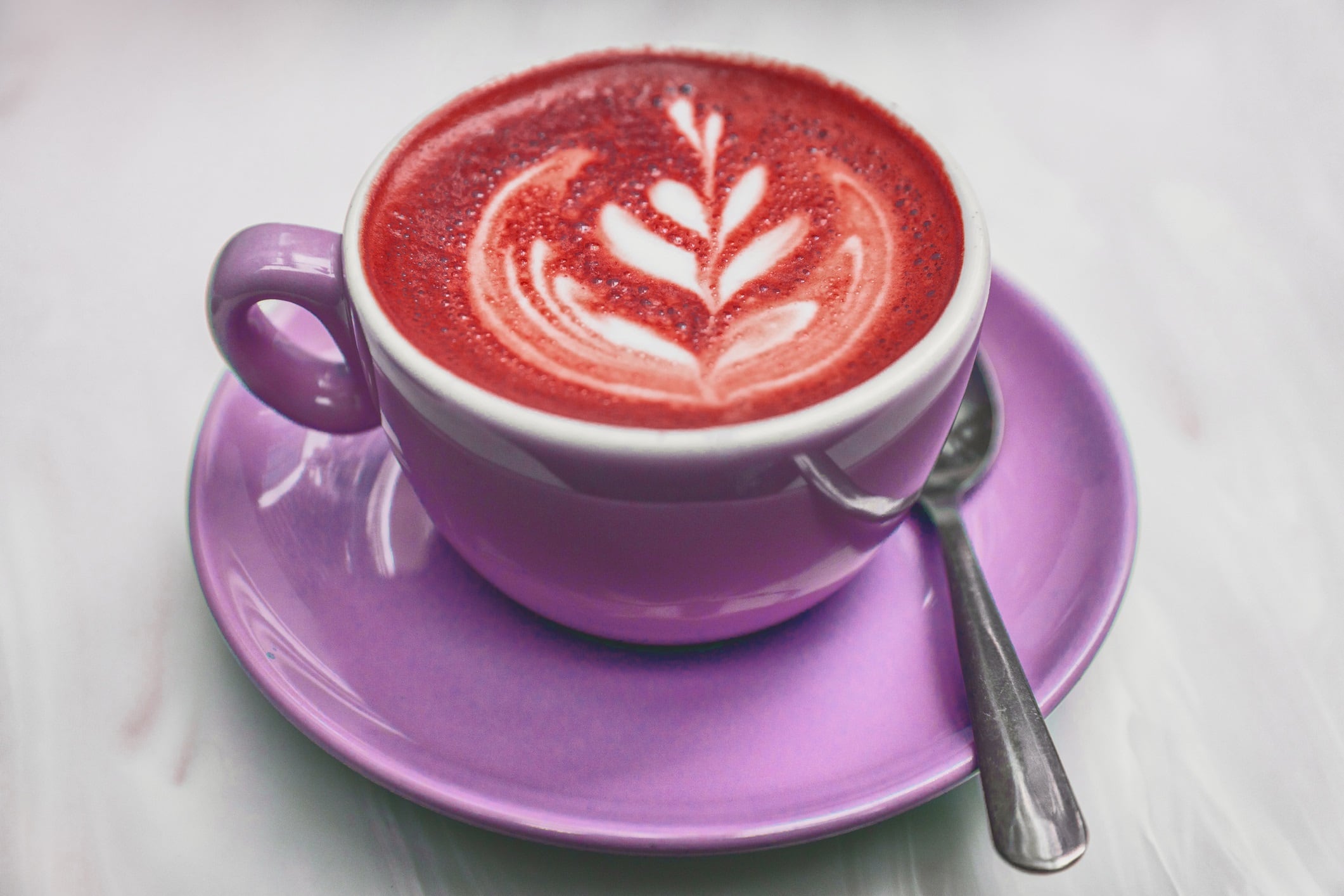 Beetroot latte coffee red beets colored milk foam on cappuccino cup in trendy food trend at american cafe restaurant. Beet drink healthy detox.