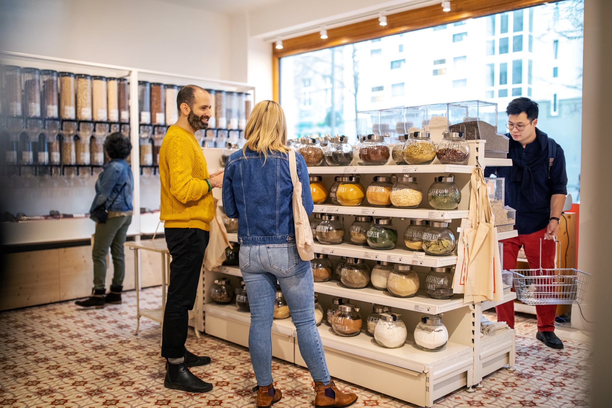 Multi-ethnic customers shopping at illuminated food at zero waste store.