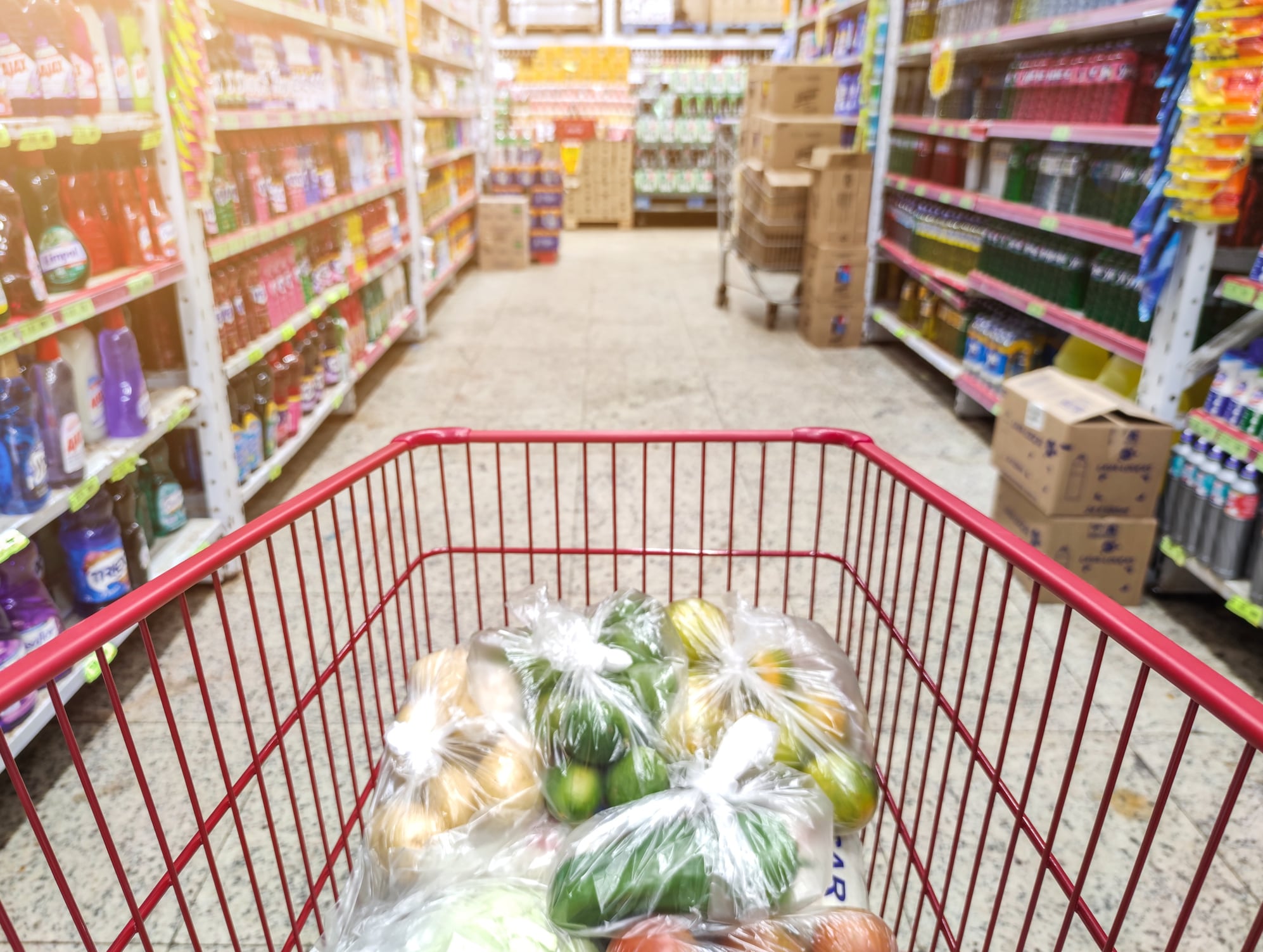 Supermarket aisle with empty shopping cart business concept.