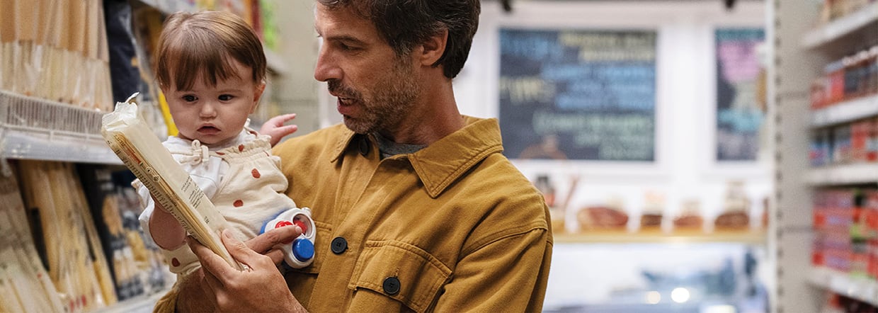 Man holding baby and shopping for natural ingredients