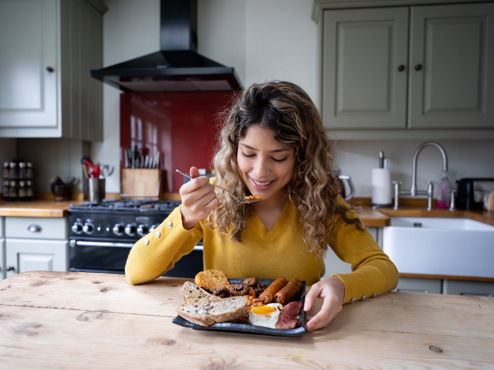 Woman at home eating an English breakfast