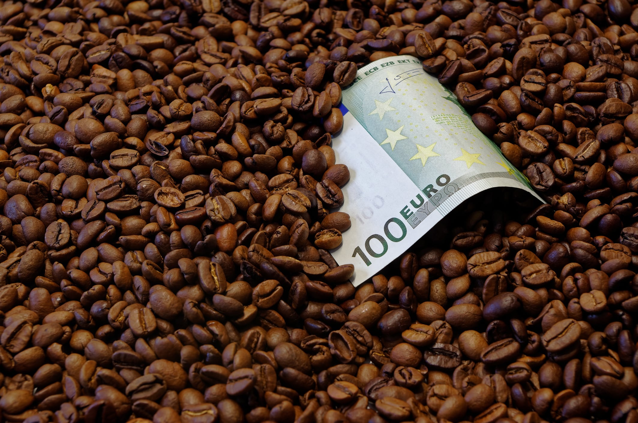 100 Euro banknote lying in the roasted coffee beans