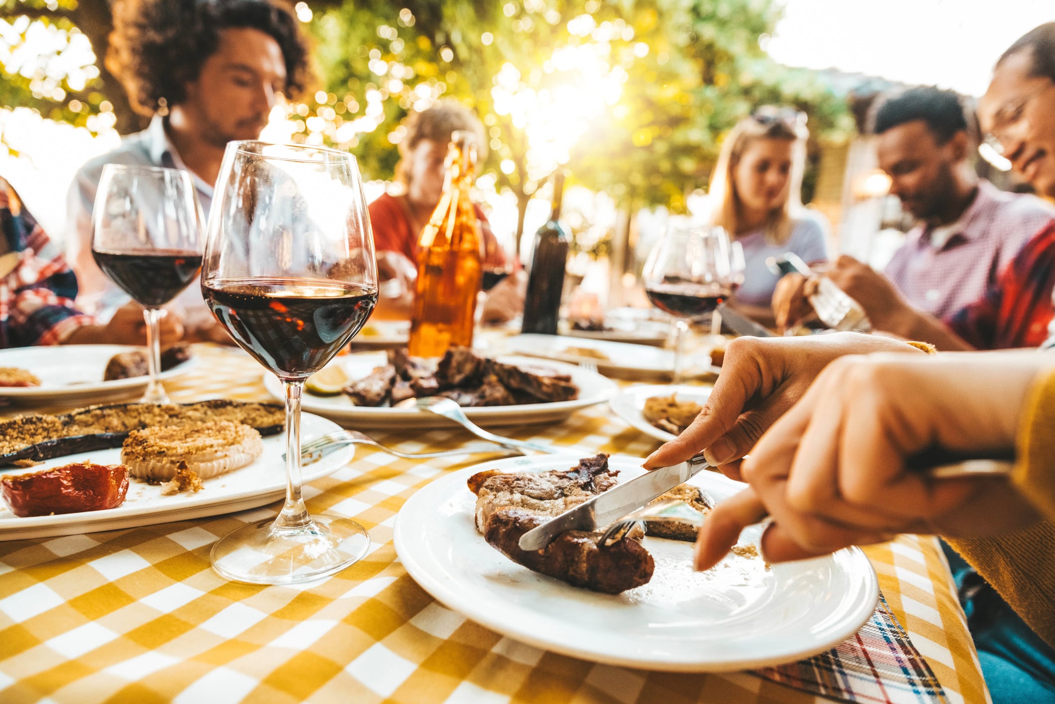 Happy friends having bbq dinner party sitting in garden restaurant table - Family enjoying lunch break together eating fresh food in home backyard - Food and beverage life style concept