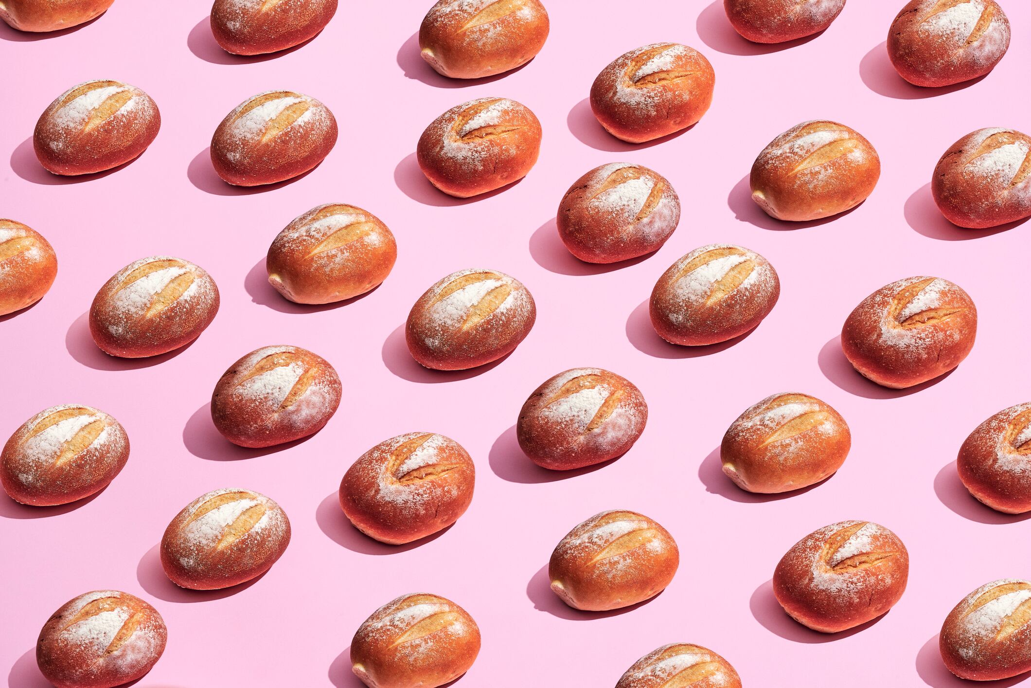 Loaves of bread in front of a pink background