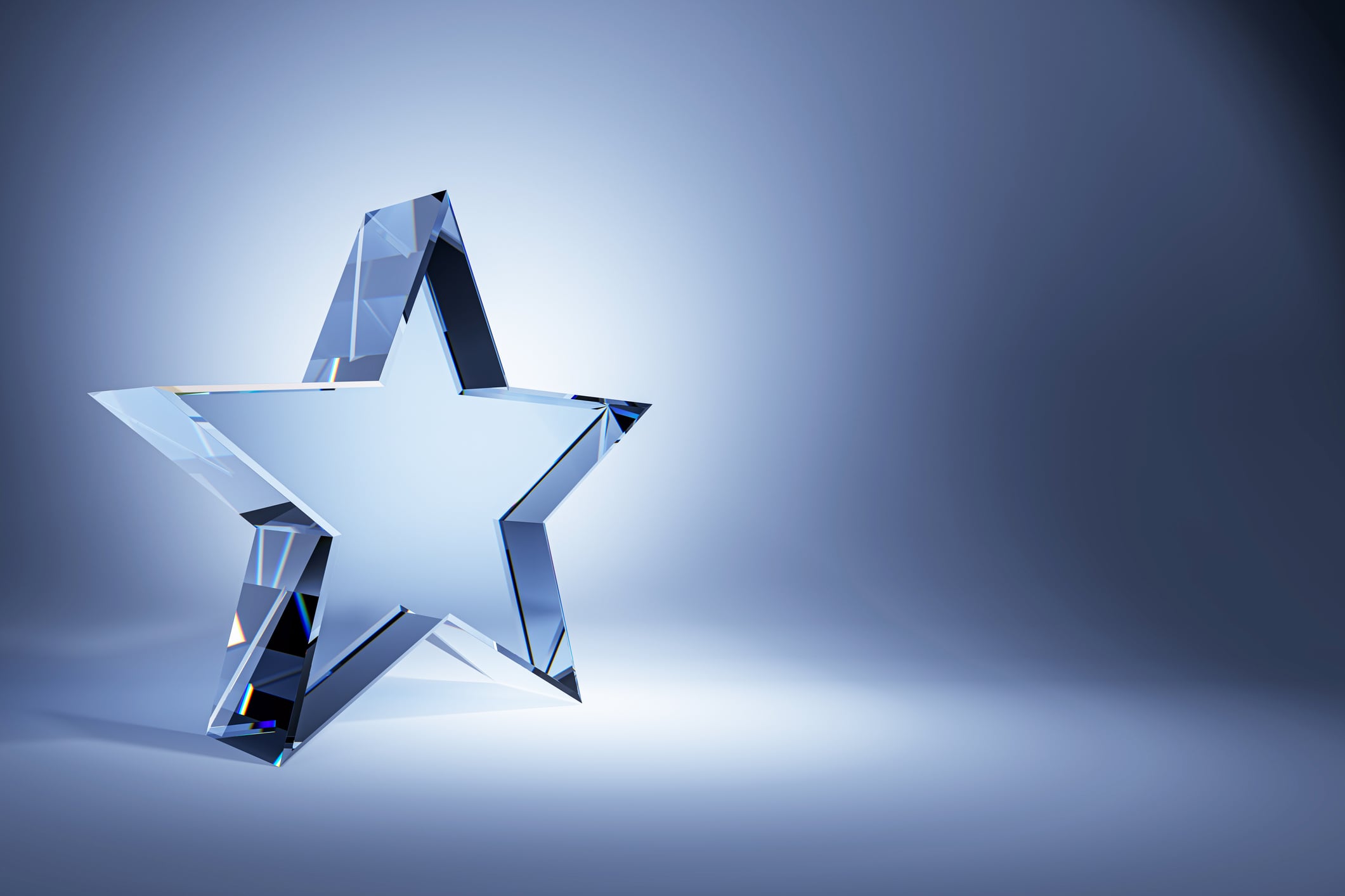 A crystal glass star trophy on a gradient blue background. The clean design and empty background make it perfect for award concepts. D Rendering.