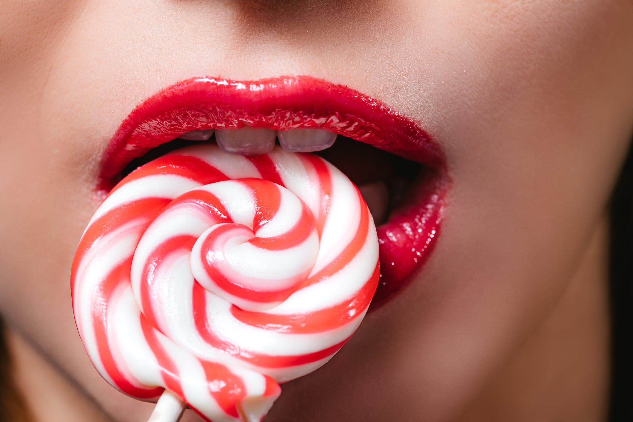 Lollypop in perfect woman teeth and red lips mouth.