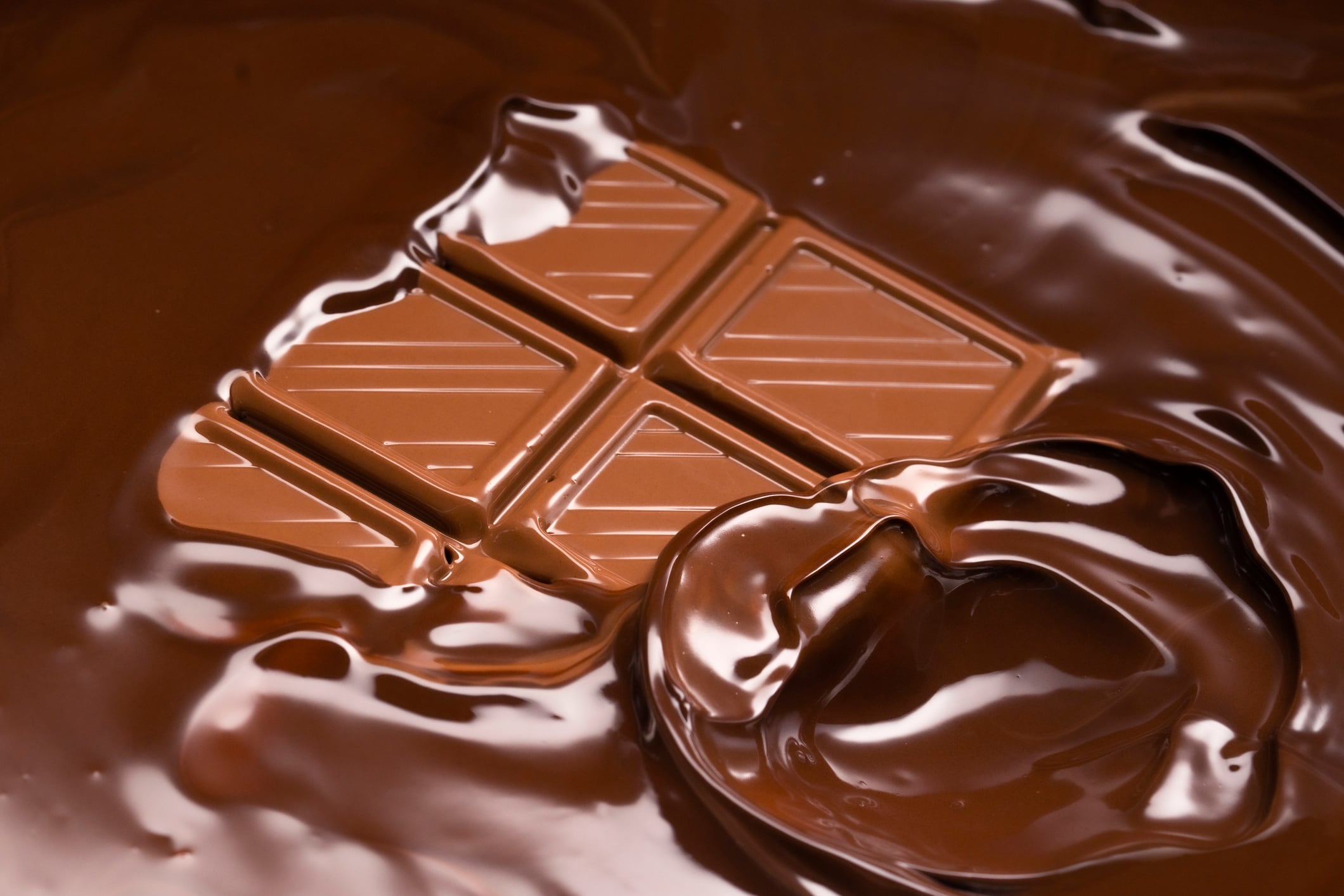 Melting chocolate bar, sinking into chocolate.