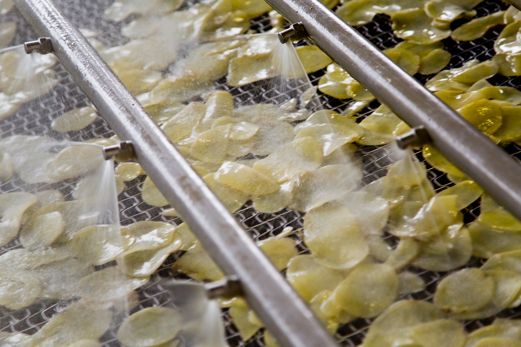 High Angle View Of Water Spraying On Potato In Machine - stock photo