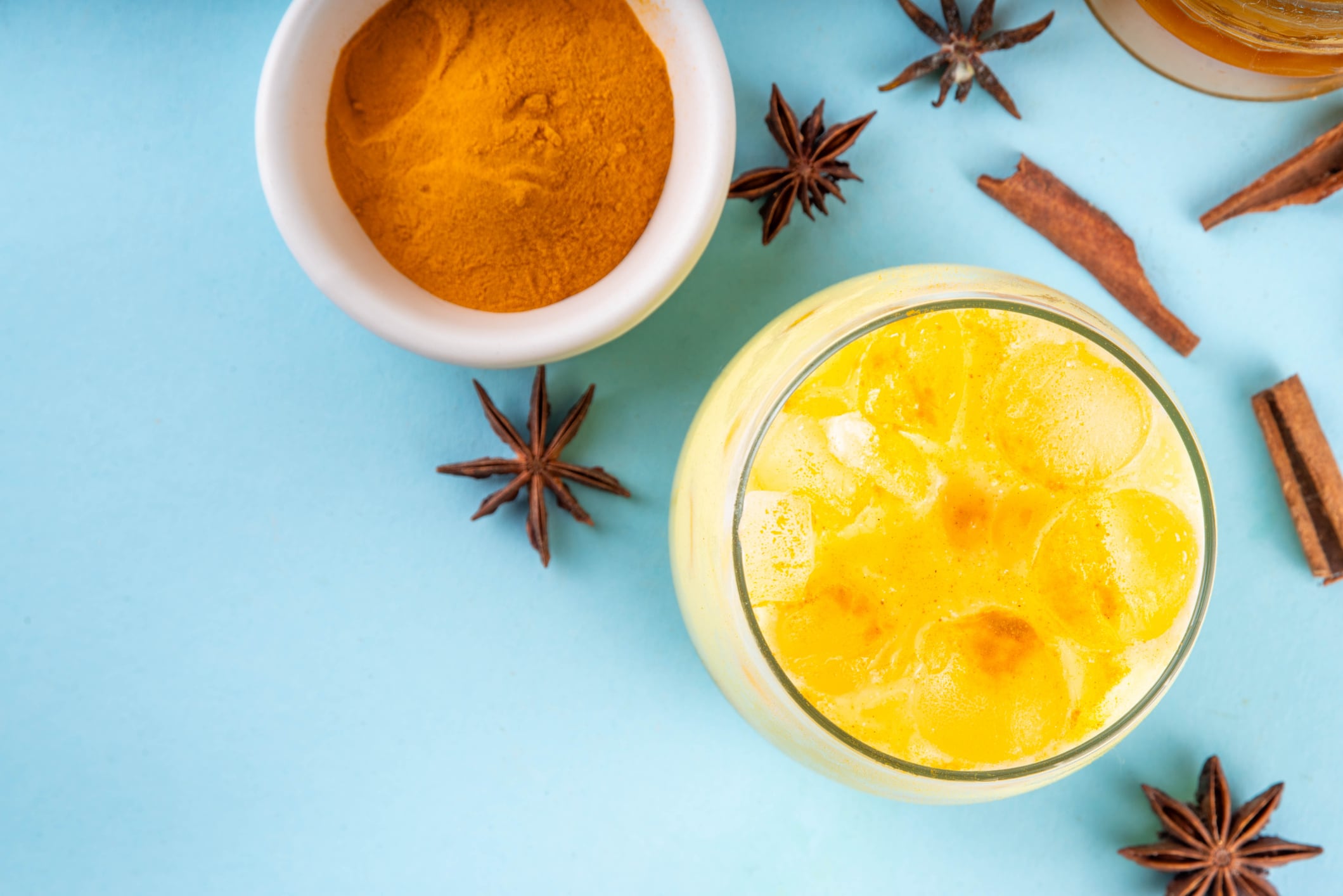 Iced golden milk drink, turmeric latte with ice cubes, Tasty summer cold beverage, alternative ayurvedic cocktail