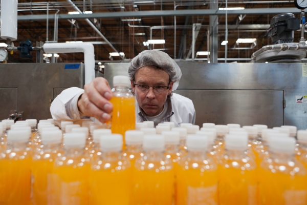 juice factory worker, hairnet, bottle  Droits d'auteur  IPGGutenbergUKLtd